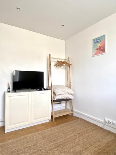 un salon avec une télévision à écran plat sur un mur blanc dans l'établissement SeaYou, à Wimereux