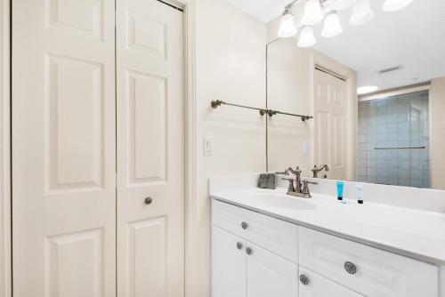 a white bathroom with a sink and a mirror at Island Princess 414 in Fort Walton Beach