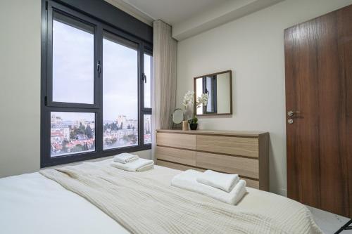a bedroom with a large bed with two towels on it at jerusalem luxury apartment in Jerusalem