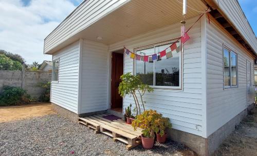 een wit huis met potplanten op de veranda bij Casa para 4 personas, en El Quisco Norte in El Quisco