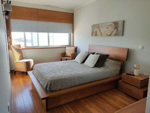 - une chambre avec un lit, une chaise et une fenêtre dans l'établissement Furadouro Pool&Beach Apart, à Ovar