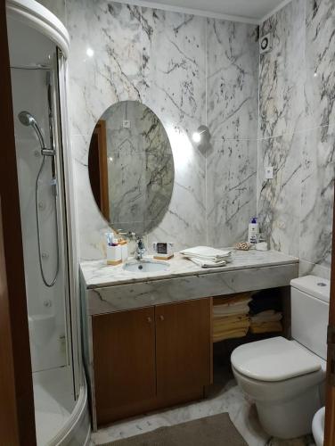 a bathroom with a sink and a toilet and a mirror at Furadouro Pool&Beach Apart in Ovar
