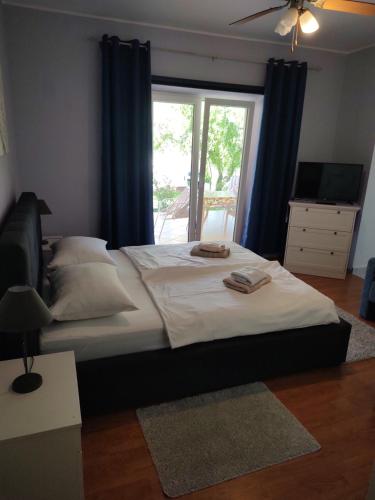 a bedroom with a large bed and a window at APP Leo in Rab