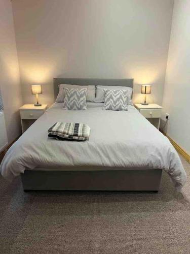 um quarto com uma cama grande e 2 mesas de cabeceira em Cheerful 2 bedroom cottage with free parking em Droíchead an Chláir