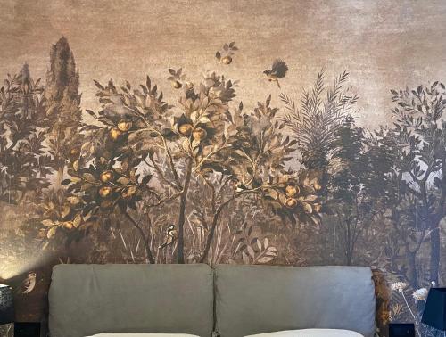 a wall with a painting of flowers and a couch at FOURHEADS Private Suites in Rome