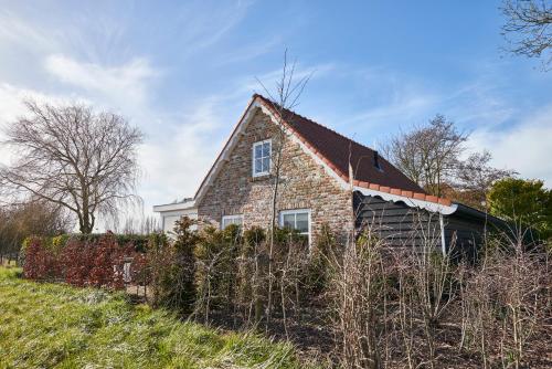 an old brick house on a hill in a field at Villa Magnolia in Oostkapelle