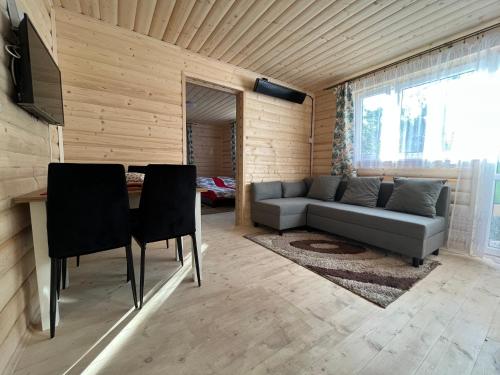 uma sala de estar com um sofá e uma mesa em Domek na górce em Sidzina