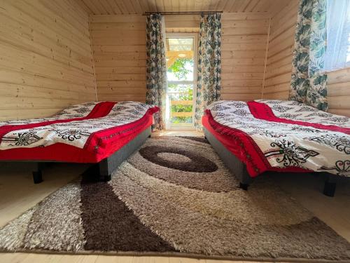two beds sitting in a room with a rug at Domek na górce in Sidzina