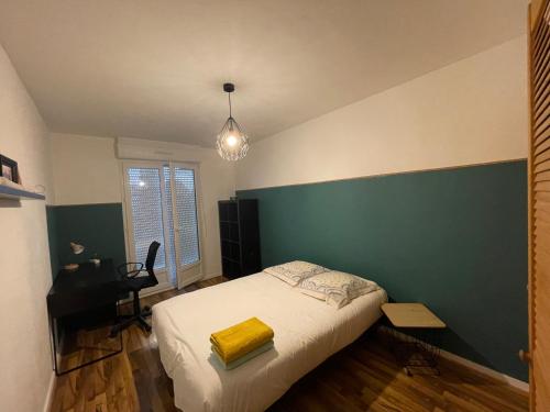 een slaapkamer met een bed met een groene accentmuur bij Appartement spacieux. P gratuit.plage à 13 min in Brest