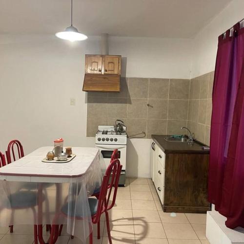 uma cozinha com uma mesa, um fogão e um lavatório em Deptos San Luis em San Rafael