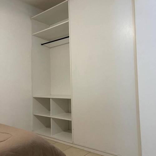 um armário branco com prateleiras brancas num quarto em Deptos San Luis em San Rafael