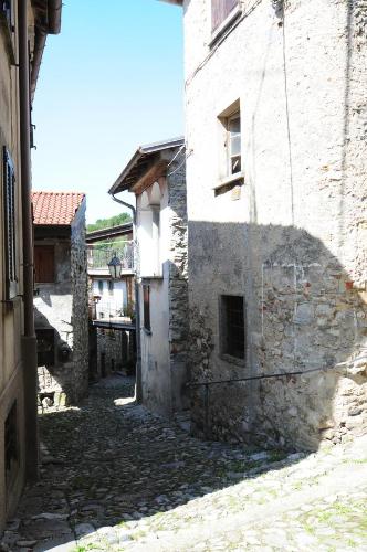 an alley in an old stone building with a shadow at Locanda del Pittore in Arcumeggia