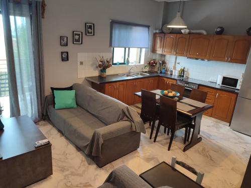 a living room and kitchen with a couch and a table at Panorama house leika kalamatas in Kalamata