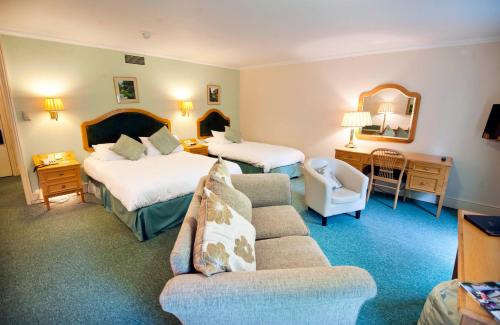 a hotel room with two beds and a couch at Penmere Manor Hotel in Falmouth