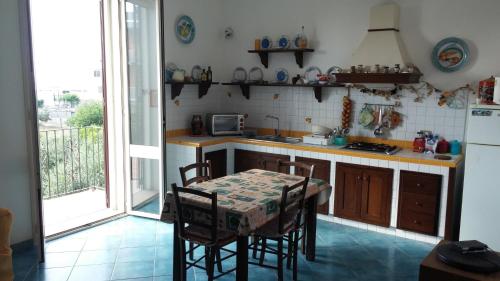 uma cozinha com uma mesa e cadeiras e uma cozinha com uma janela em Casa Vista Mare em Avola