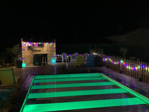 a swimming pool lit up at night with lights at Gite de campagne rénové in Le Champ-Saint-Père