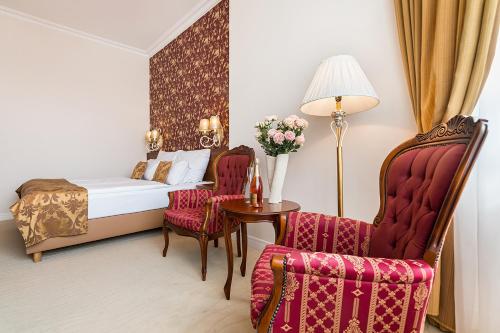 a bedroom with a bed and a table and chairs at Hotel Katerina in Znojmo