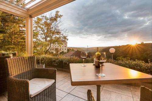 - une table avec deux verres de vin sur la terrasse dans l'établissement Hotel Katerina, à Znojmo