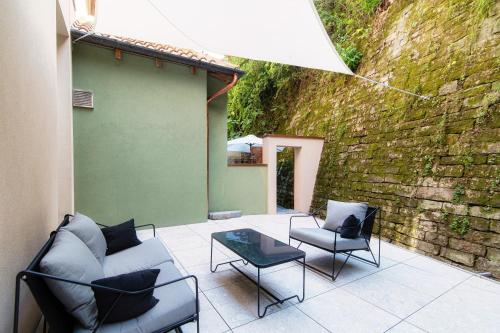 a patio with chairs and a couch and a table at Suites Lorodellago Como - The House Of Travelers in Como