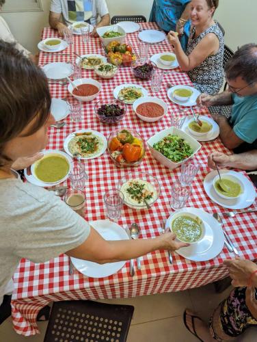 a group of people sitting at a table eating food at guest house אשראם בכרמל - אכסניה in Dāliyat el Karmil