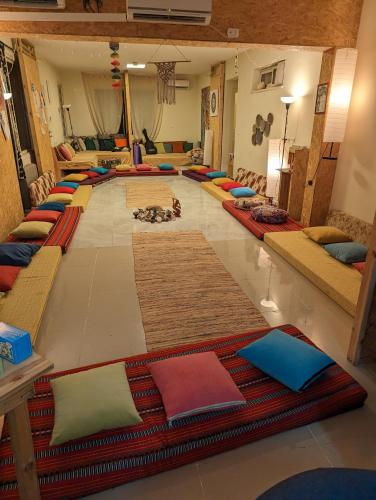 a large room with many pillows on the floor at guest house אשראם בכרמל - אכסניה in Dāliyat el Karmil