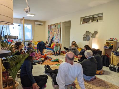 a group of people sitting on the floor in a room at guest house אשראם בכרמל - אכסניה in Dāliyat el Karmil