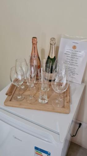 a tray with wine glasses on top of a refrigerator at Flor de Lis Chalés in Paraty