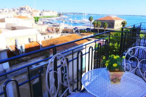balcone con tavolo e vista sul porto di Allen apartments a Siracusa