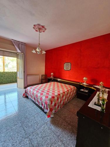 1 dormitorio con paredes rojas, 1 cama y piscina en Casetta Vannella, en Valderice