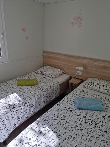 two beds in a small room with two beds sidx sidx sidx at Mobile home Sea Jezera Village, otok Murter in Tisno