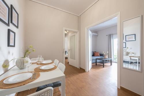 uma sala de jantar branca com uma mesa e cadeiras em Comfortable Apartment In Athens em Atenas