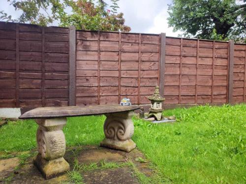 a stone bench in front of a fence at Serendipity in Manchester