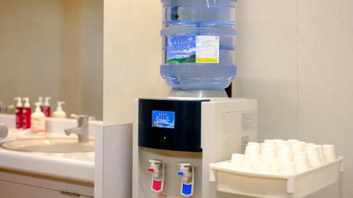 a water dispenser in a bathroom with a sink at Mitsui Bekkan in Yonago