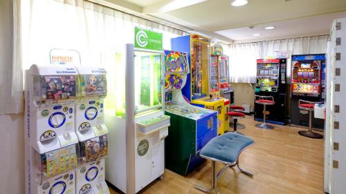 a room with several arcade games and a chair at Mitsui Bekkan in Yonago