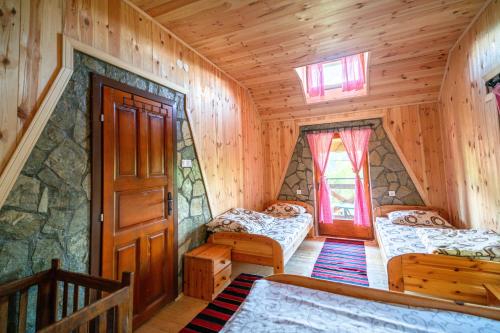 sypialnia z 2 łóżkami w drewnianym domku w obiekcie Country Villa MMMM w mieście Mojkovac