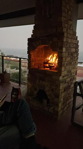 a brick fireplace with a fire in it at Ocean View in Margate