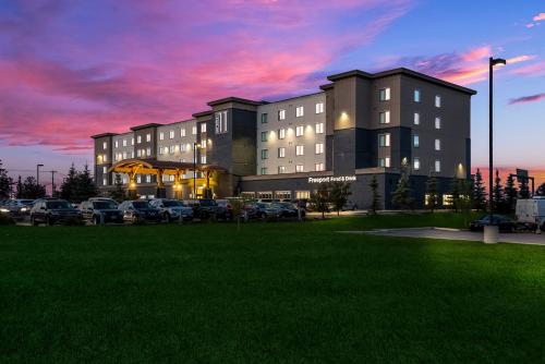 a building with cars parked in a parking lot at Hotel 11, MOD A Sonesta Collection in Calgary