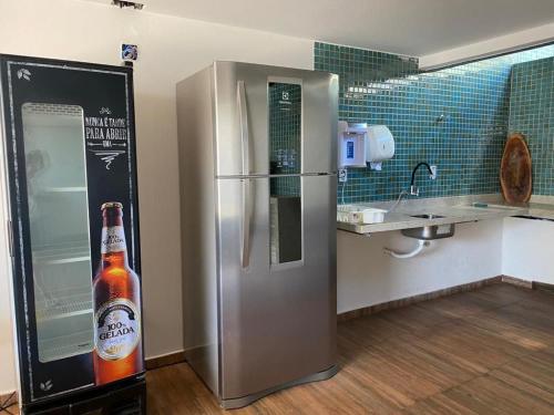 a bottle of beer sitting next to a refrigerator at Apartamento na Praia dos Milionários in Ilhéus