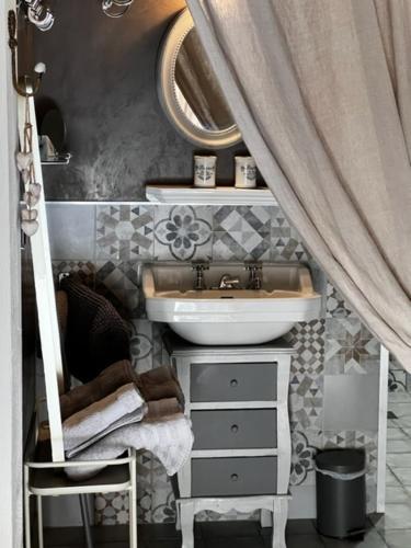 een badkamer met een wastafel, een spiegel en een wastafel bij Le Paillé de Torreilles in Torreilles