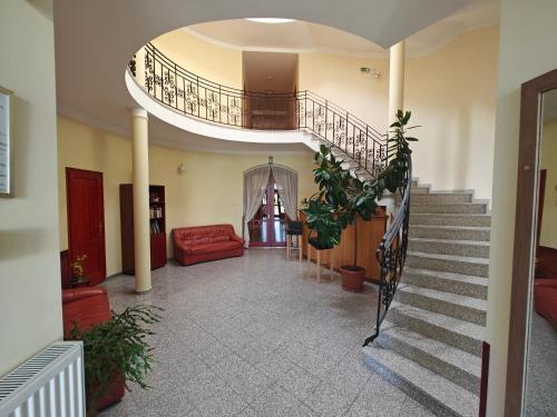 a hallway with a staircase with a red couch at Villa Lira in Hévíz