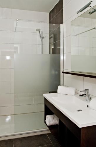 a bathroom with a sink and a shower at Bodensee-Hotel Sonnenhof in Kressbronn am Bodensee