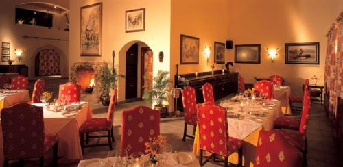 a dining room with tables and chairs with red chairs at Pakamisa Private Game Reserve in Pongola