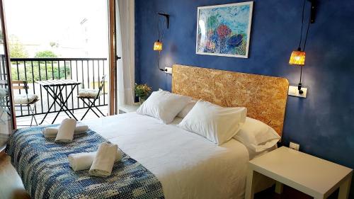 Un dormitorio con una cama blanca con una pared azul. en Masquestar Rías Altas, en Foz