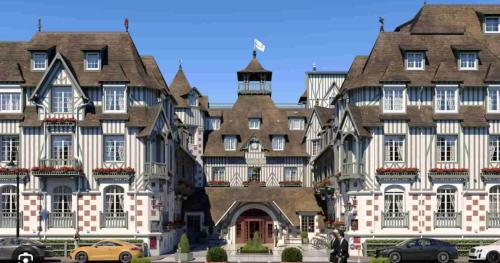 ein großes Gebäude, vor dem Autos parken in der Unterkunft Grand studio hyper centre avec balcon TOUT REFAIT MARS 2025 in Deauville