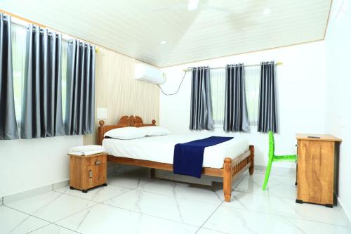 een slaapkamer met een bed en een groene stoel bij Bliss Homestay Munroe Island in Munroe Island