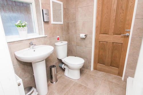a bathroom with a toilet and a sink at Pheasant lodge - Balmaha 3 bed in Glasgow