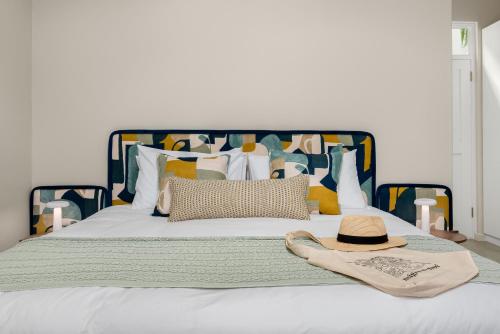 a white bed with a hat and a hat at Neighbourgood Franschhoek in Franschhoek