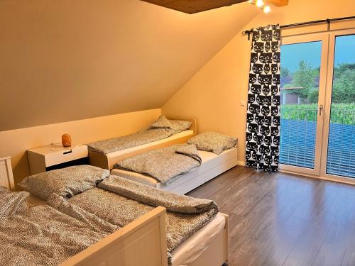 2 Betten in einem Zimmer mit Fenster in der Unterkunft Haus am Wald in Schrozberg