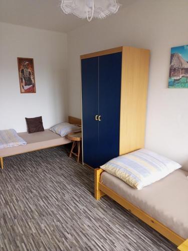 フルボカー・ナト・ヴルタヴォウにあるUbytování u Janyのベッド2台と青いキャビネットが備わる客室です。