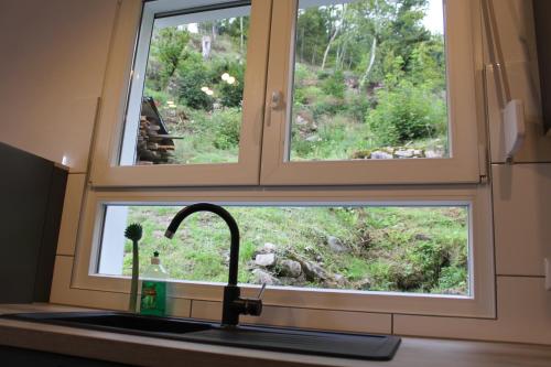 a kitchen sink with a window above a kitchen counter at Ferienhaus Rauhfelsen in Baiersbronn